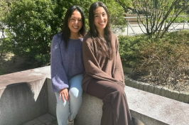 Leni and Michelle Lemos sit outside of the Peter T. Paul College of Business and Economics.