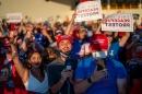 A group of people wearing Trump 2020 gear at a Trump rally.